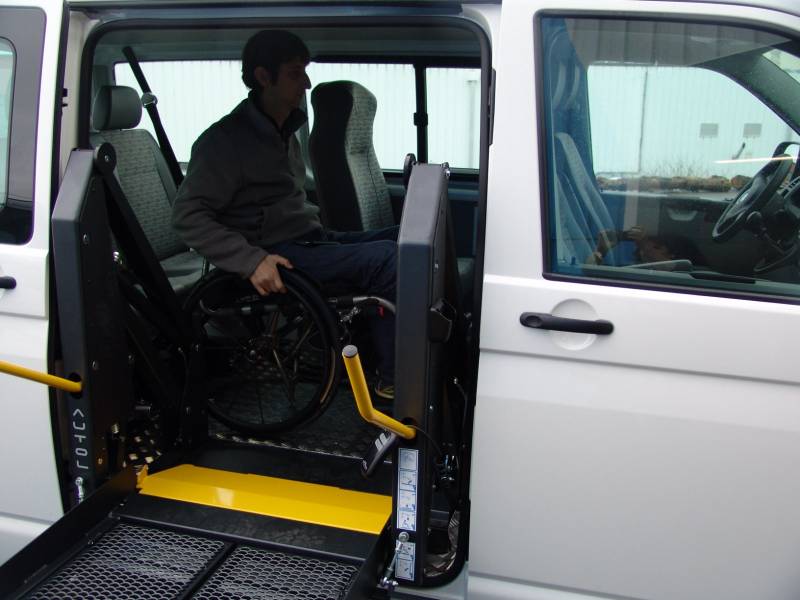 Hayon élévateur pour personne en fauteuil roulant dont l'encombrement est minimisé.